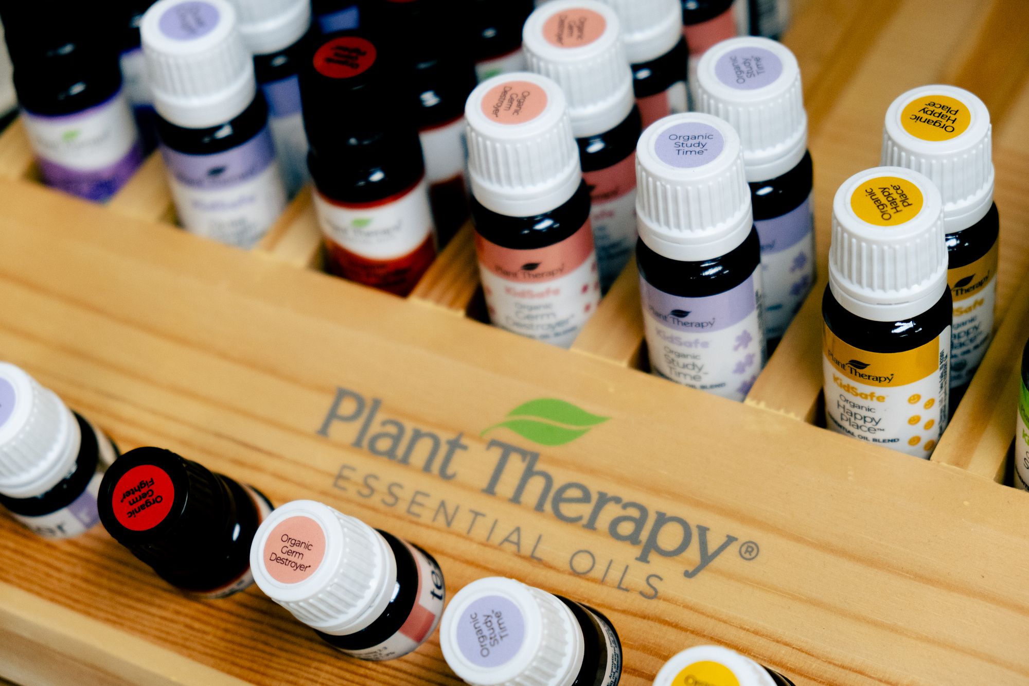 Plant Therapy essential oil bottles in a wooden display case